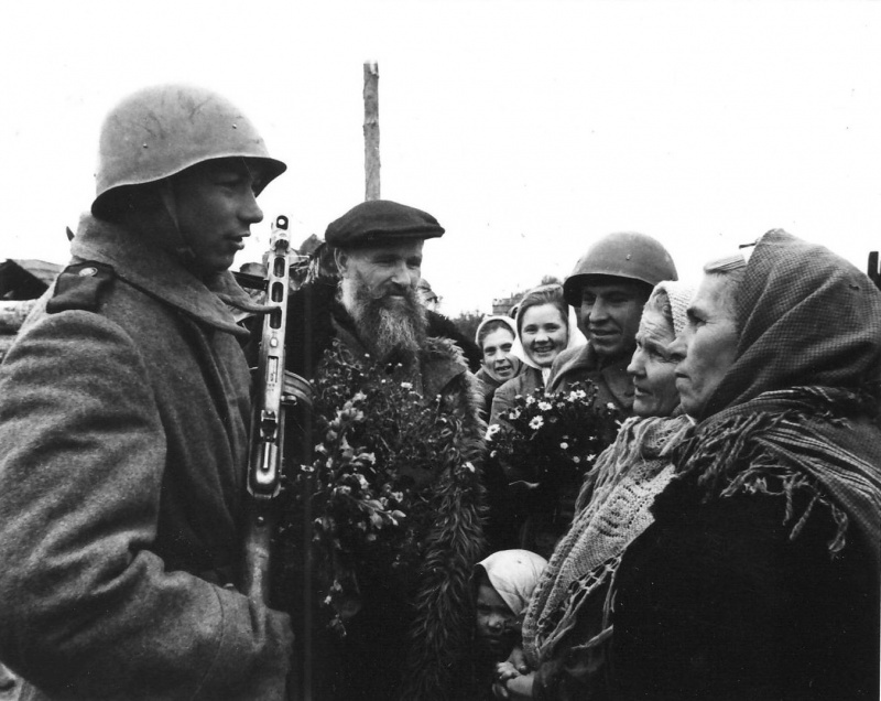 ​Жители освобожденного Невеля с цветами встречают советских солдат. waralbum.ru - На пороге партизанского края | Warspot.ru