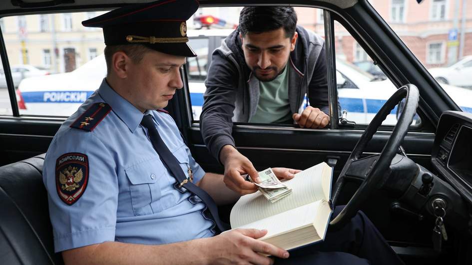 Мигрант попытался передать взятку инспектору спрятав деньги в кодексе